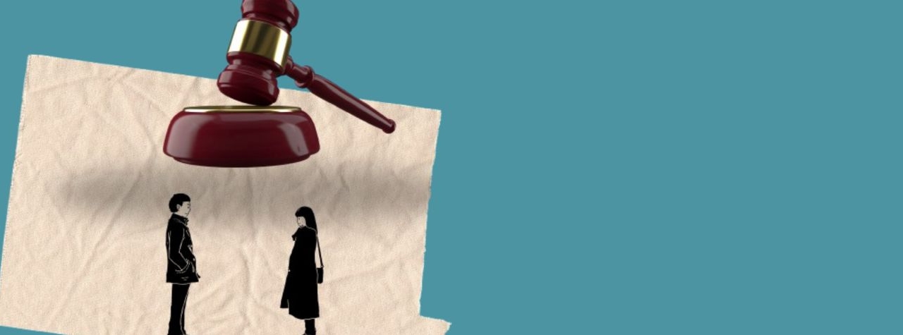 Illustration of a gavel looming overhead above a man and a woman standing apart on a crumpled sheet of paper, set against a plain teal background.