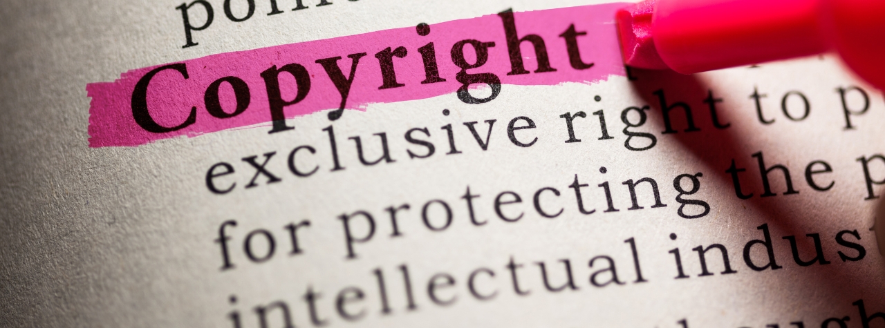 Close-up of a document with the word “Copyright” highlighted in pink by a red marker.